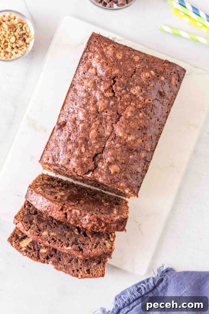 Whole brownie banana bread loaf on a white cutting board with several slices cut in front.