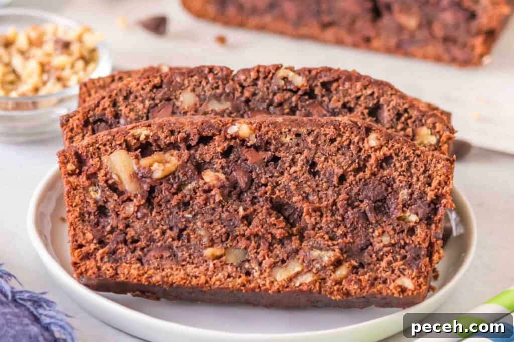 Two slices of brownie banana bread on a white plate with chocolate chips and walnuts visible.