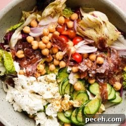 Salad with chickpeas, cucumbers, cherry tomatoes, prosciutto, cheese, and mixed greens.