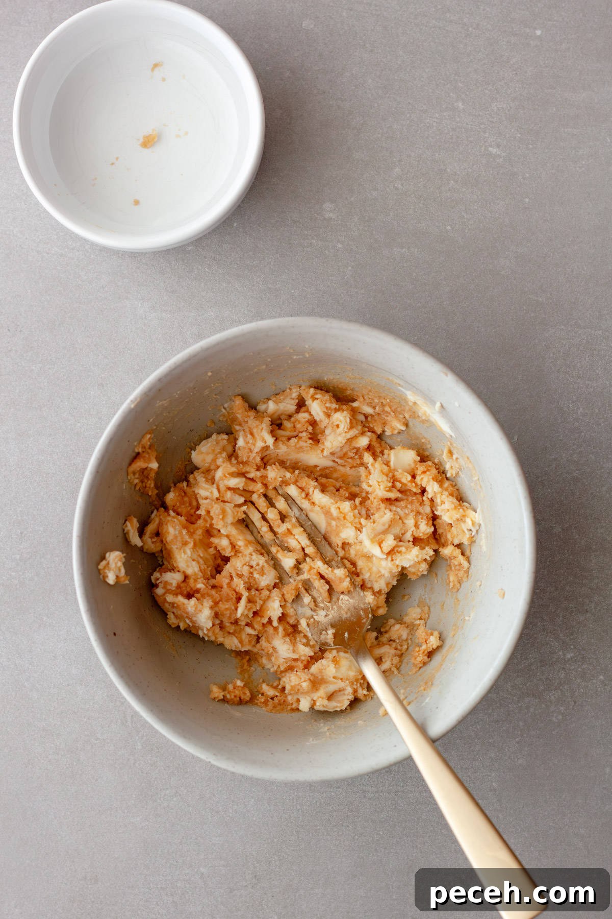 Savory Miso Butter Recipe for Bread, Veggies, and Steak 4 Butter and miso getting smashed together by a fork in a gray bowl.