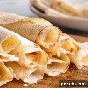 Authentic Norwegian Potato Lefse Recipe for Soft, Sweet Flatbread 11 A wooden board with rolled up potato lefse.