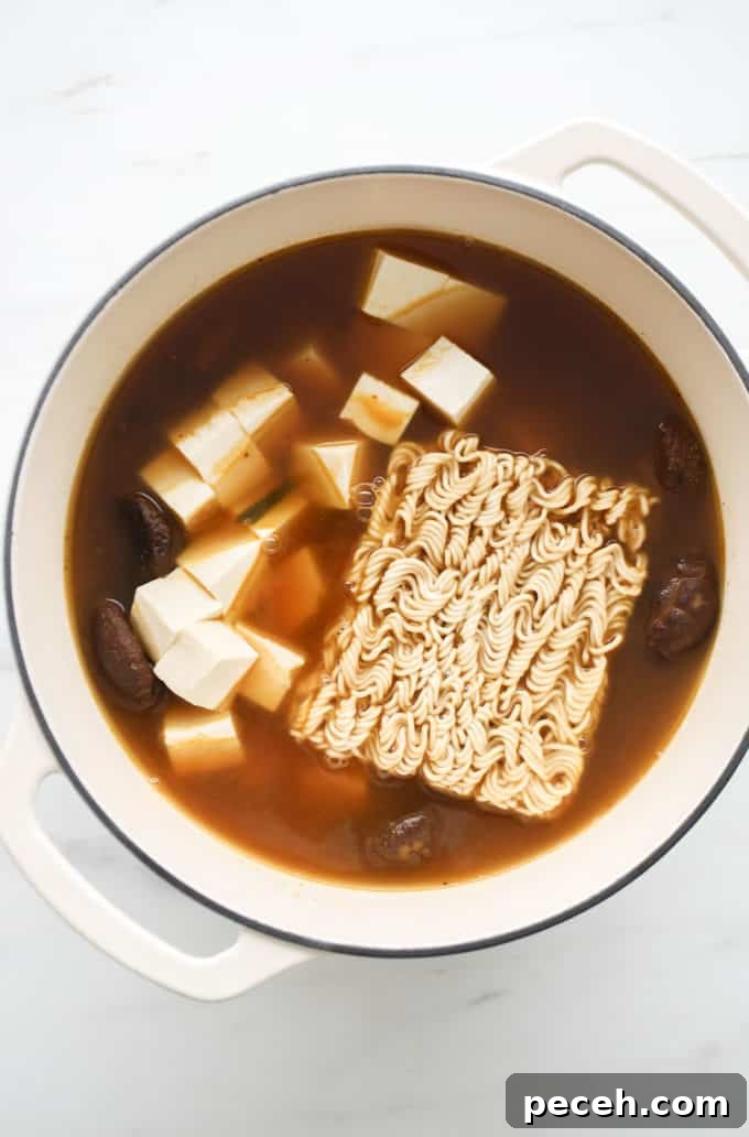 Vegan Ramen Recipe: Fast Homemade Broth and Noodles 10 Vegan ramen soup with tofu and ramen noodles in a white pot