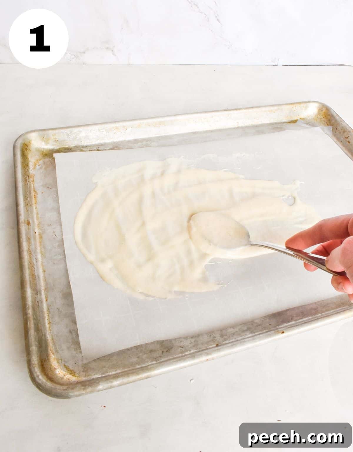 How to Make and Maintain a Sourdough Starter at Home 10 spoon spreading thin layer of starter on parchment paper.