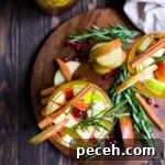 Autumn Harvest White Sangria Recipe for Cozy Fall Gatherings 6 Overhead shot of two glasses filled with autumn harvest white sangria, garnished with rosemary and cinnamon sticks.