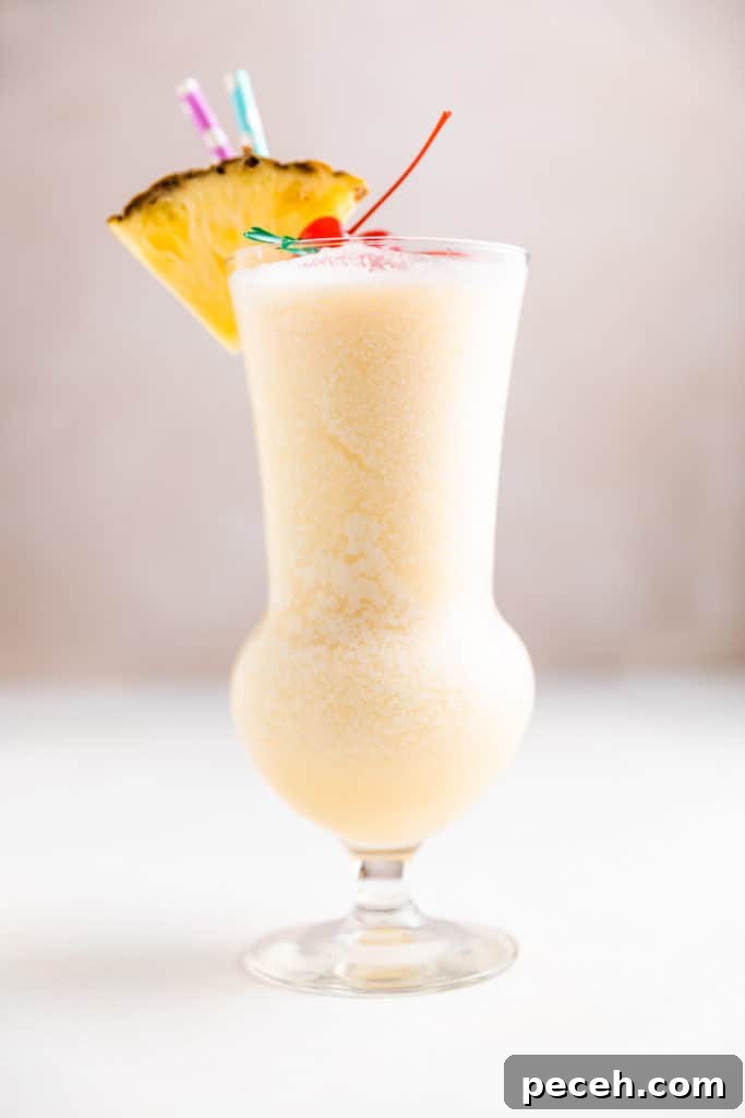 Classic Piña Colada Recipe: How to Make the Tropical Cocktail at Home 2 Side view of a pineapple coconut cocktail.