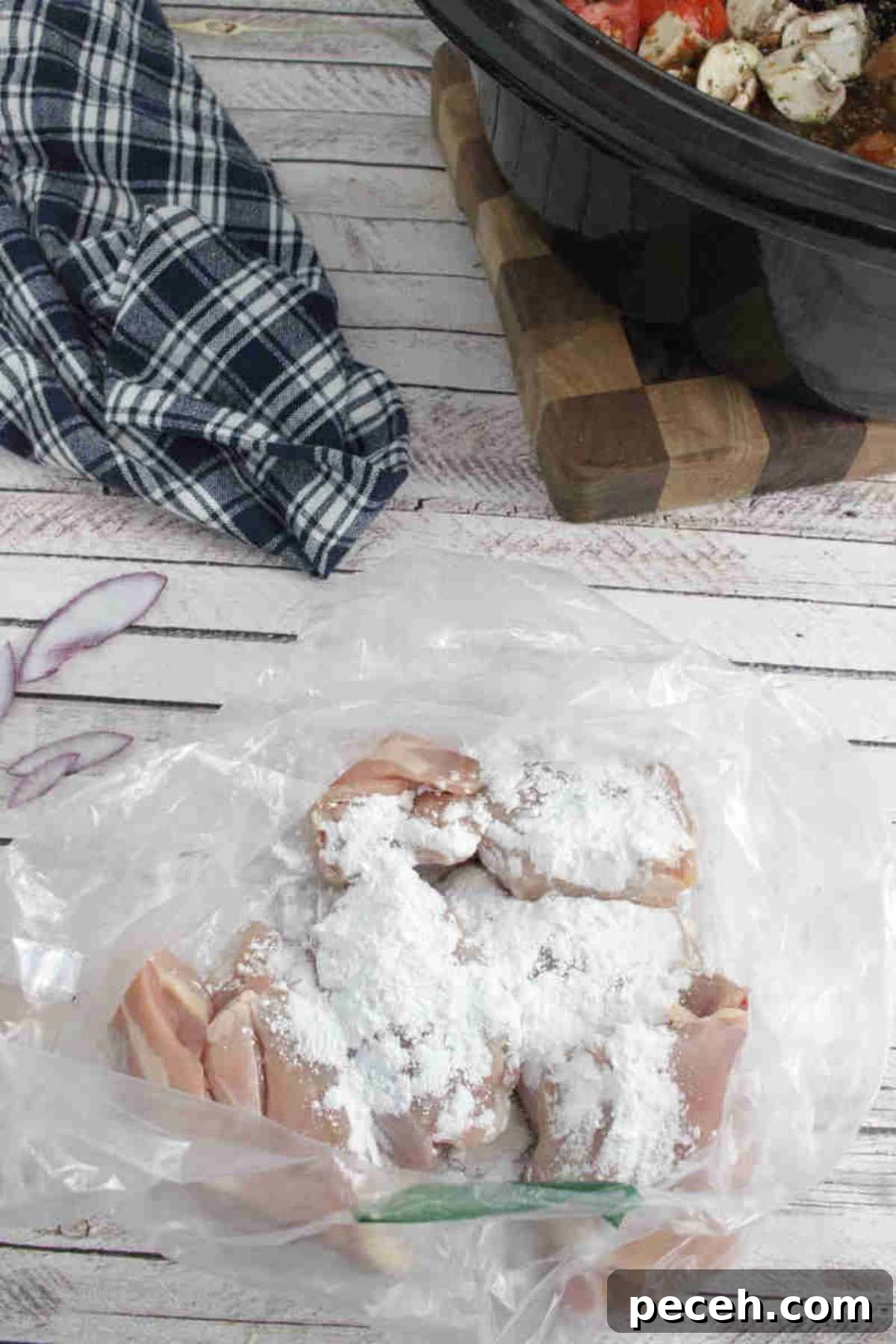 Raw chicken thighs with tapioca flour on them in a plastic baggie.