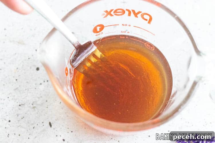 Honey Lavender Syrup Recipe for Lattes, Cocktails & Desserts 7 fork stirring liquid