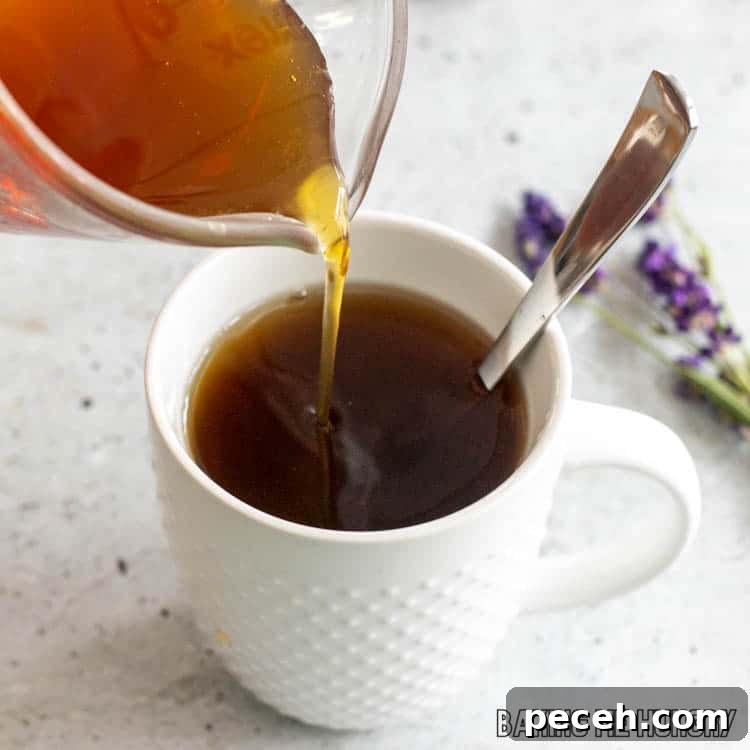 Honey Lavender Syrup Recipe for Lattes, Cocktails & Desserts 9 honey lavender syrup being poured into tea