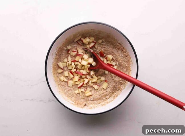 Muffin batter with apples in a bowl.