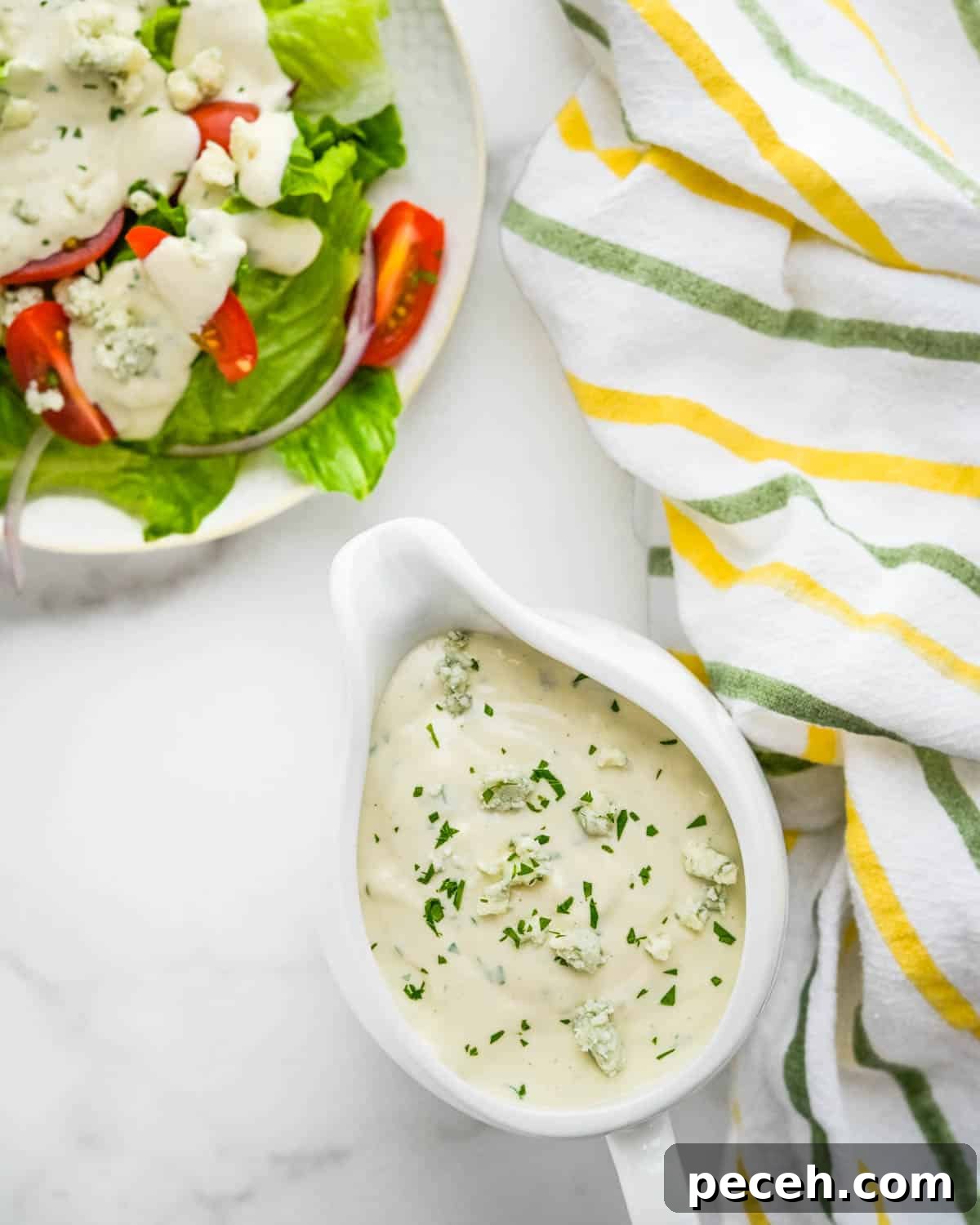 Creamy Chunky Blue Cheese Dressing Recipe 7 A green salad with a pitcher of blue cheese dressing on the side.