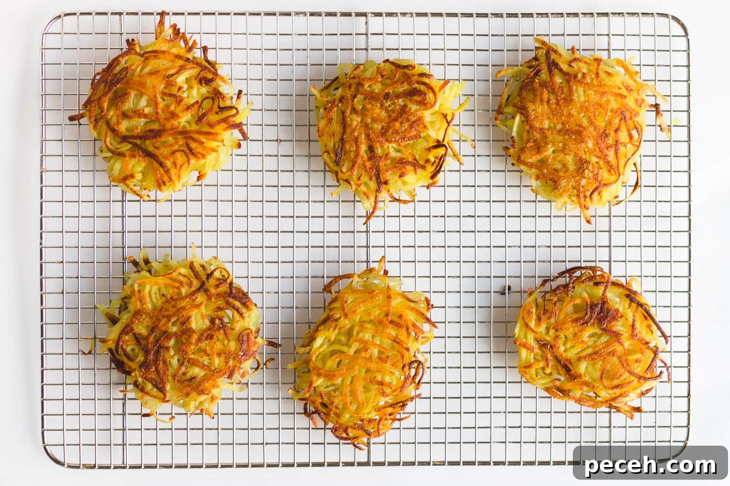 Rösti Eggs Benedict with Crispy Potato Cakes 4 Overhead shot of 6 rosti on a metal cooling rack