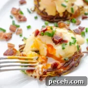 A fork cutting into Rosti Eggs Benny on a white plate garnished with chopped bacon and chives.