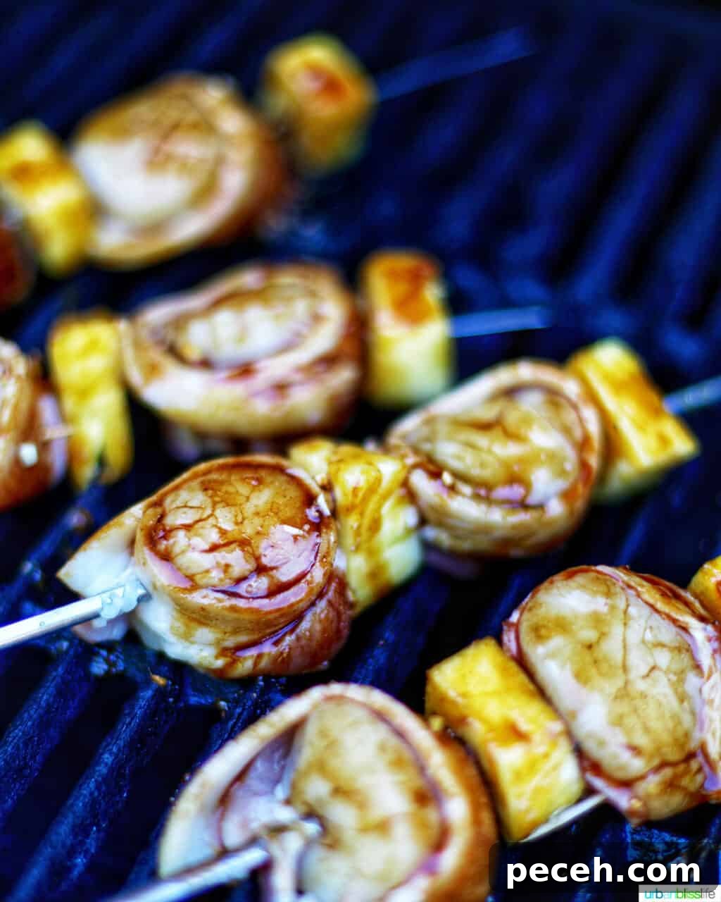 Teriyaki-Glazed Bacon-Wrapped Scallops on the Grill 5 grilled bacon-wrapped scallop skewers with pineapple on the grill