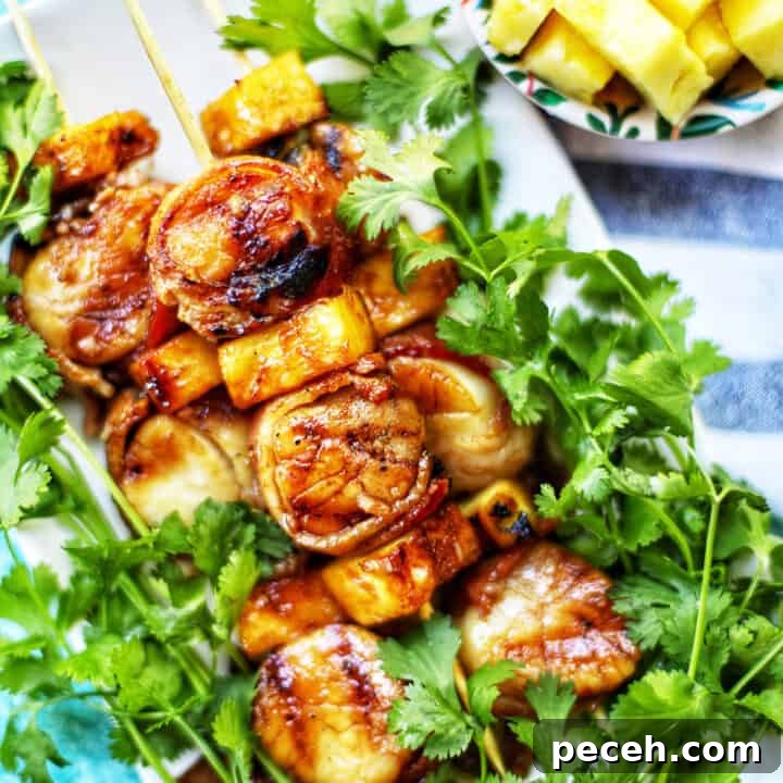 Teriyaki-Glazed Bacon-Wrapped Scallops on the Grill 6 grilled bacon wrapped scallops on bed of lettuce.