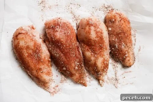 Juicy Bacon-Wrapped Chicken Breast Recipe for Dinner 11 raw chicken breast with seasonings on top.