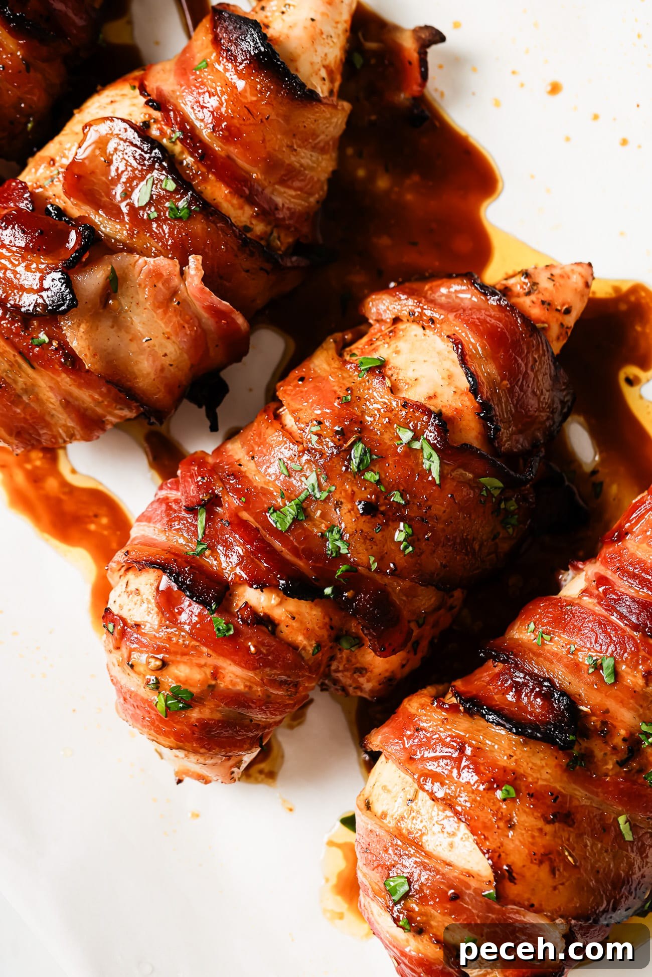 Juicy Bacon-Wrapped Chicken Breast Recipe for Dinner 8 A close-up of bacon-wrapped chicken breasts garnished with parsley.