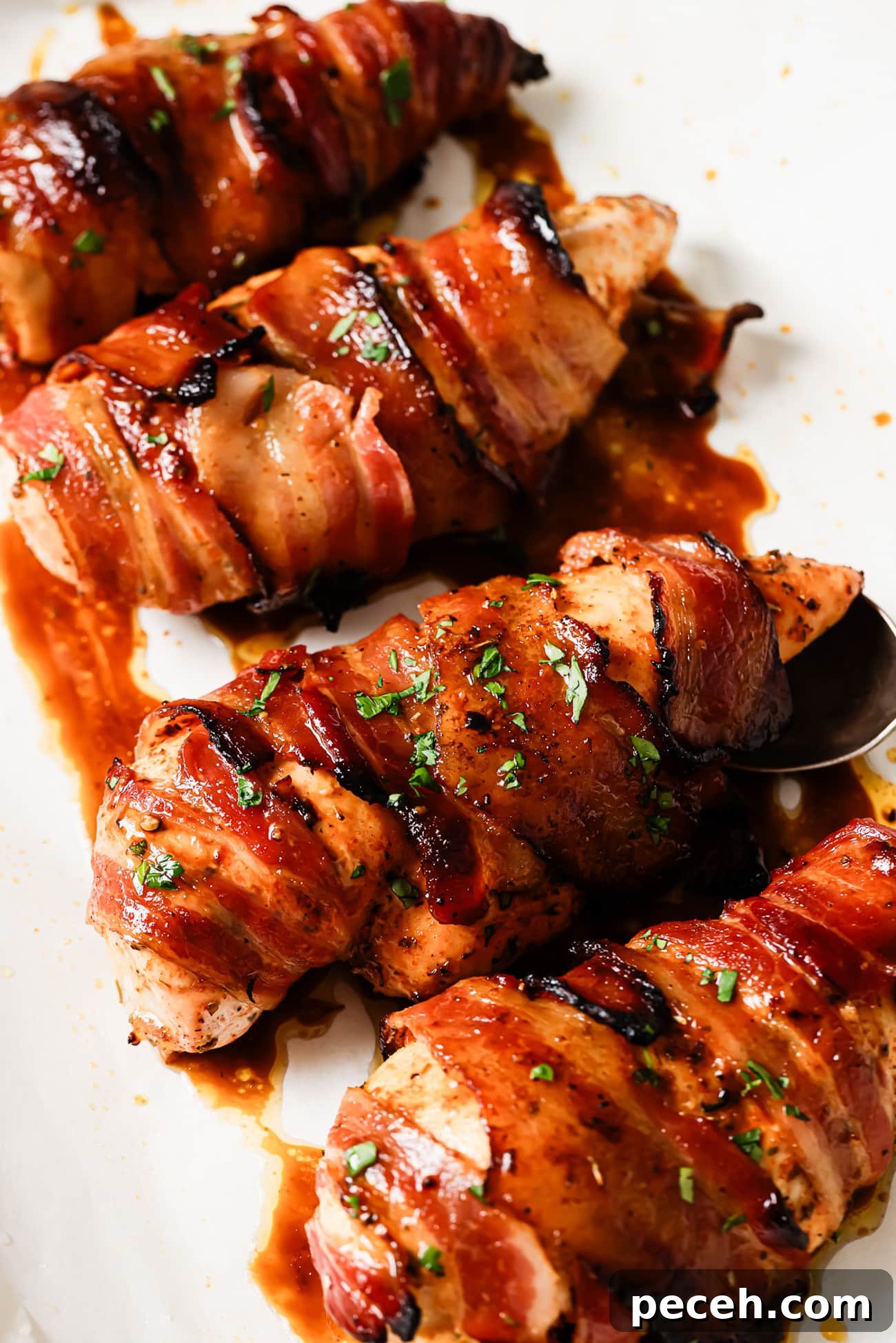Juicy Bacon-Wrapped Chicken Breast Recipe for Dinner 9 A close-up of bacon-wrapped chicken breasts garnished with parsley.