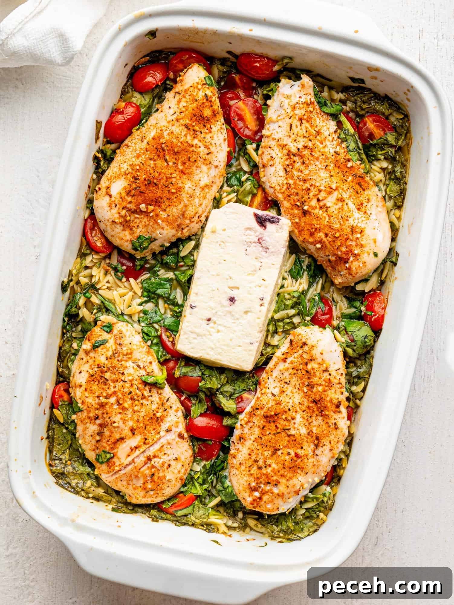 Spinach, Feta & Chicken Orzo Bake — Cheesy One-Pan Dinner 12 Chicken and Orzo Bake in a white casserole dish.