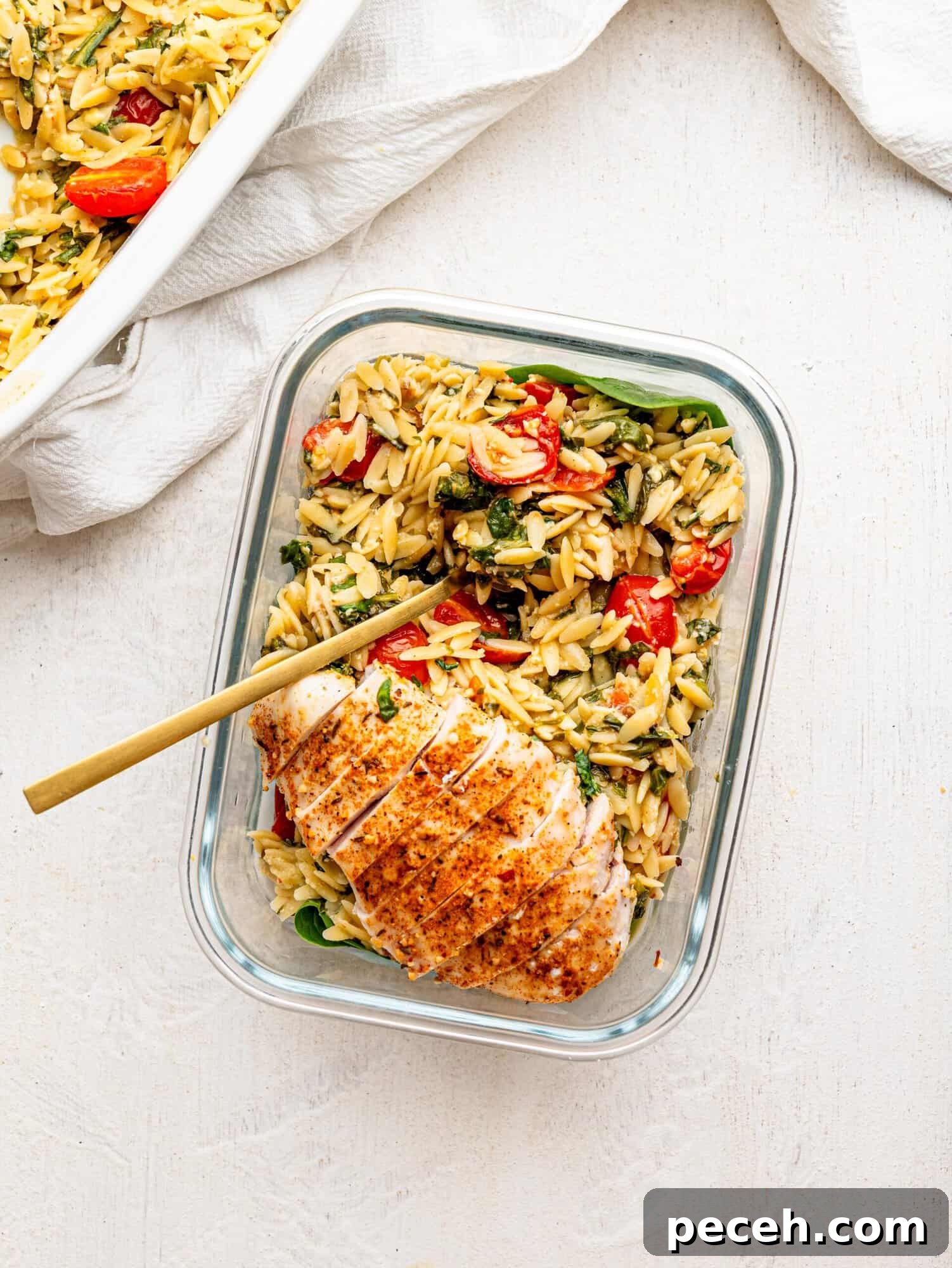 Spinach, Feta & Chicken Orzo Bake — Cheesy One-Pan Dinner 14 Chicken and Orzo Bake in a glass meal-prep container.