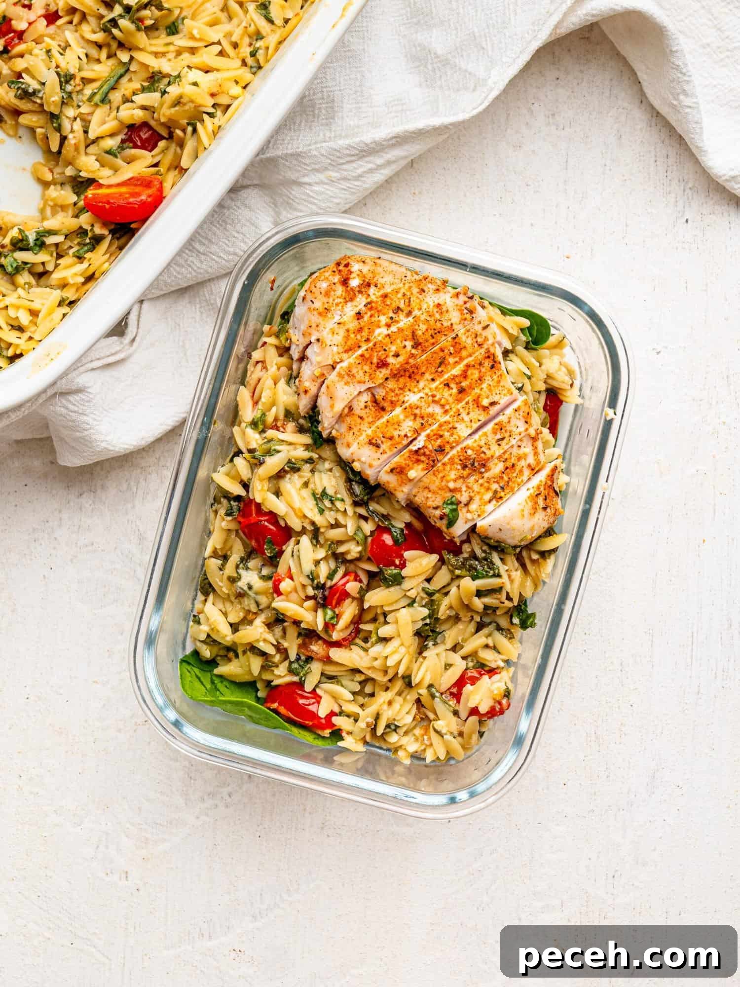 Spinach, Feta & Chicken Orzo Bake — Cheesy One-Pan Dinner 4 Chicken and Orzo Bake in a glass meal-prep container.