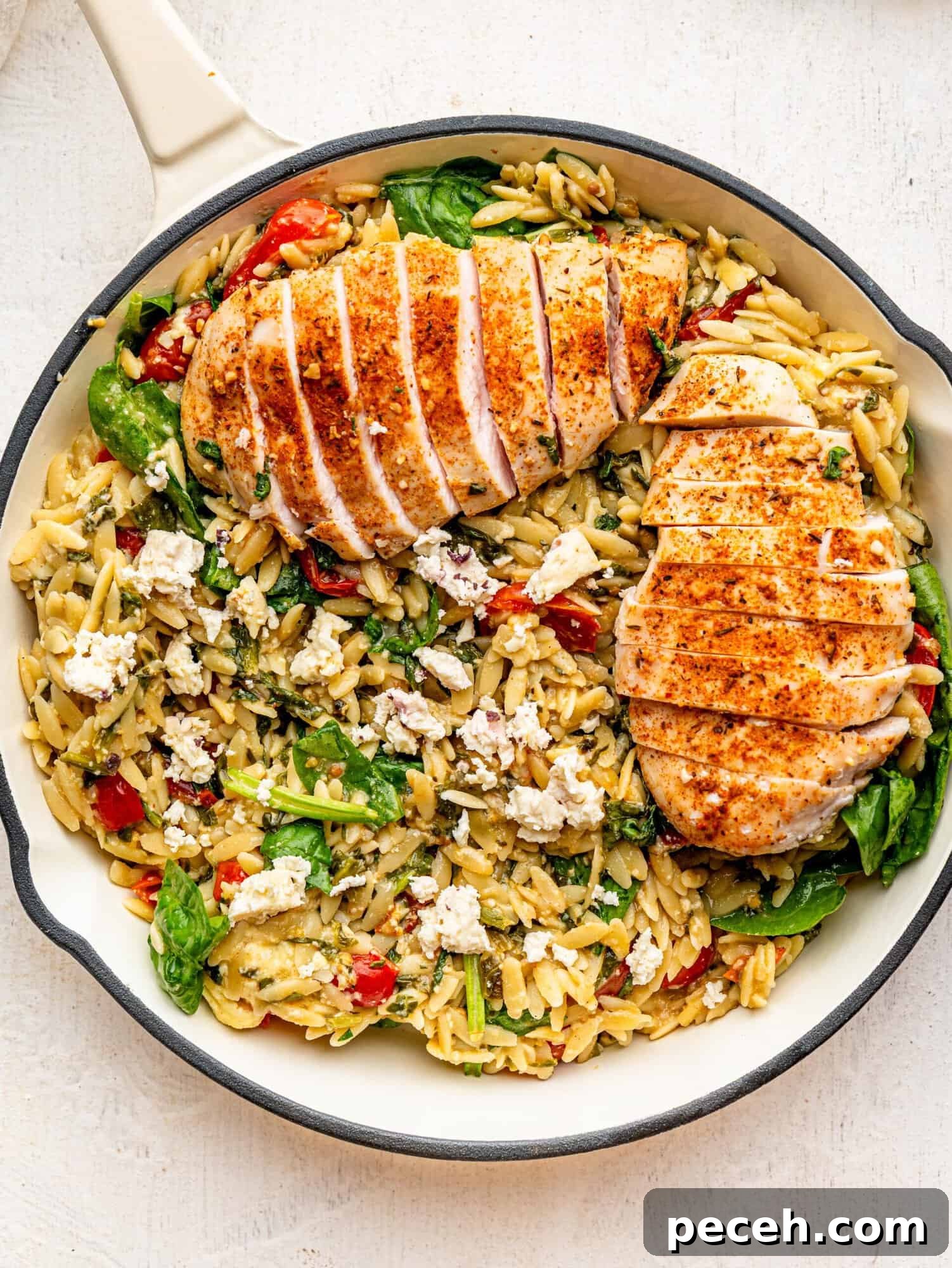 Spinach, Feta & Chicken Orzo Bake — Cheesy One-Pan Dinner 6 Chicken and Orzo Bake in a white skillet.