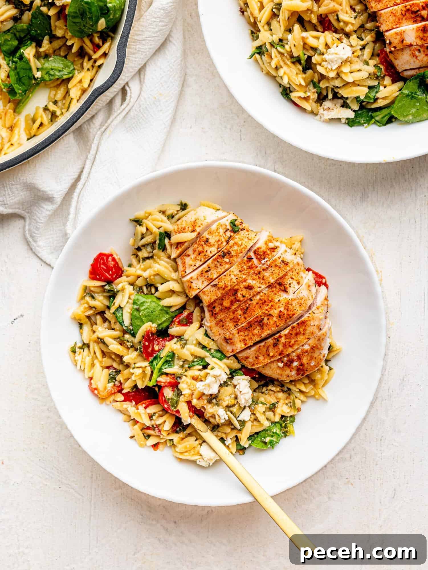 Spinach, Feta & Chicken Orzo Bake — Cheesy One-Pan Dinner 7 Chicken and Orzo bake in a white bowl.