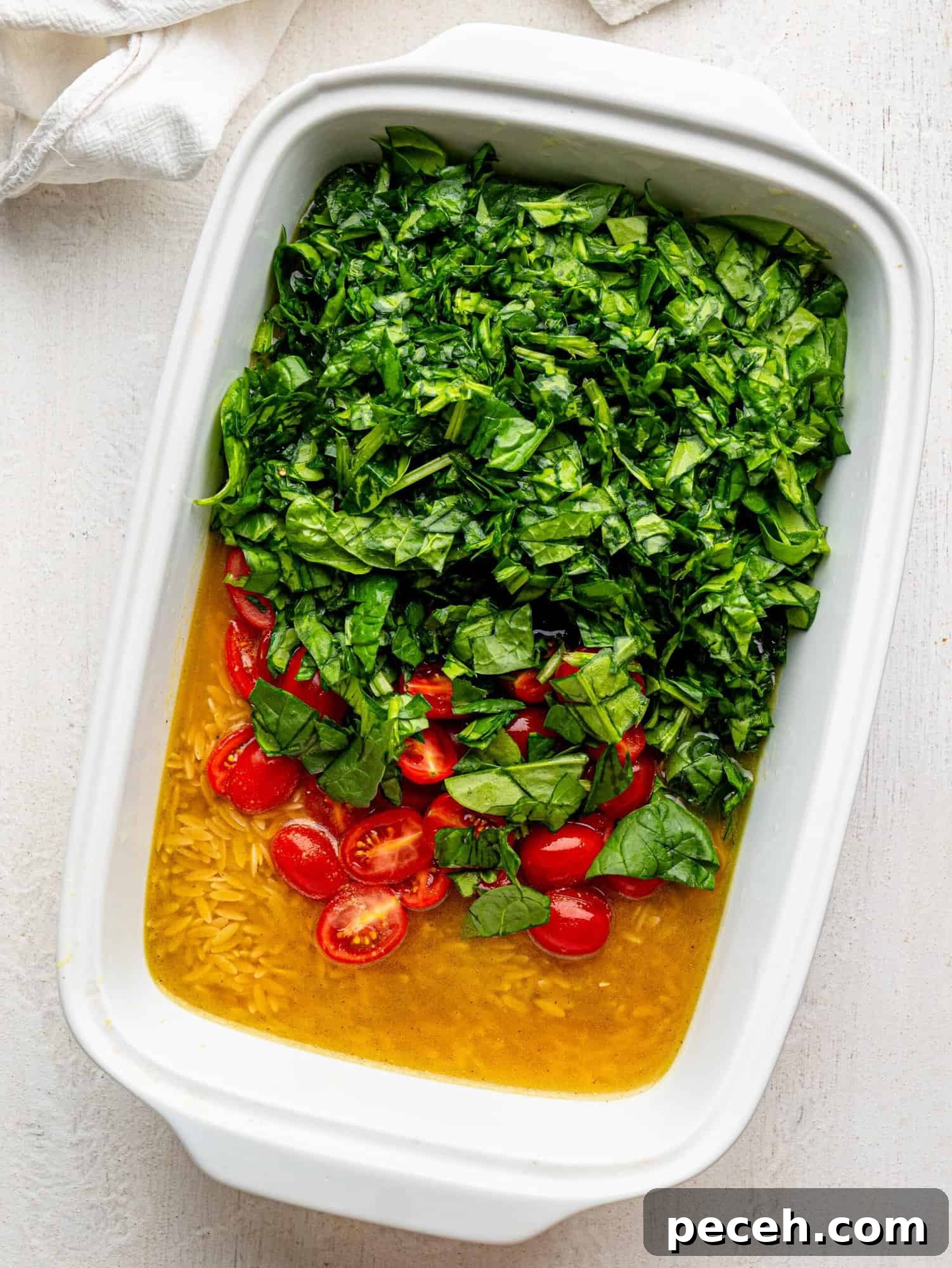 Spinach, Feta & Chicken Orzo Bake — Cheesy One-Pan Dinner 9 Spinach and Feta Orzo Bake ingredients in a white casserole dish before baking.