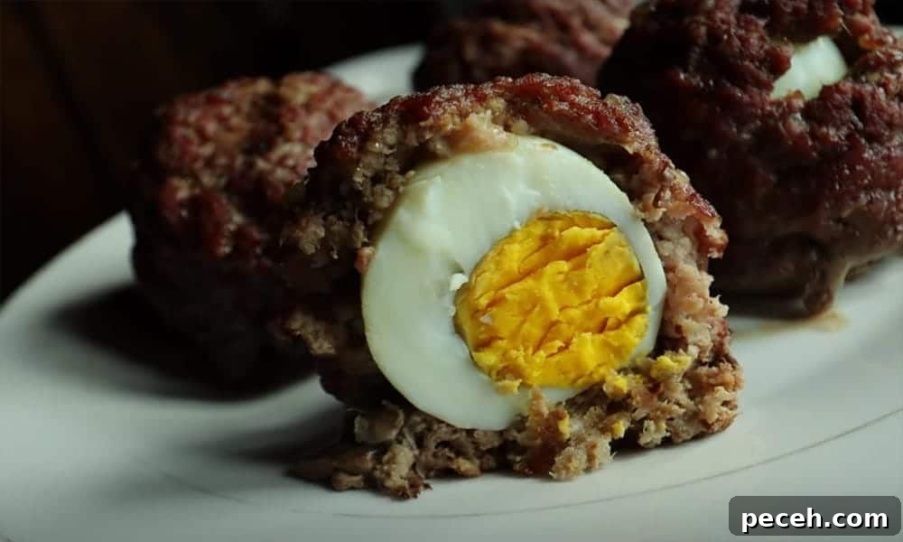 Scotch eggs with ground beef one cut in half.