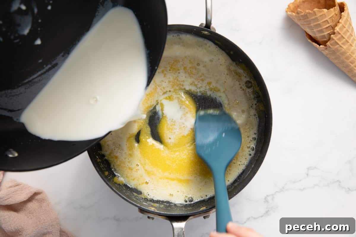 Milk being tempered with egg yolks in a pan