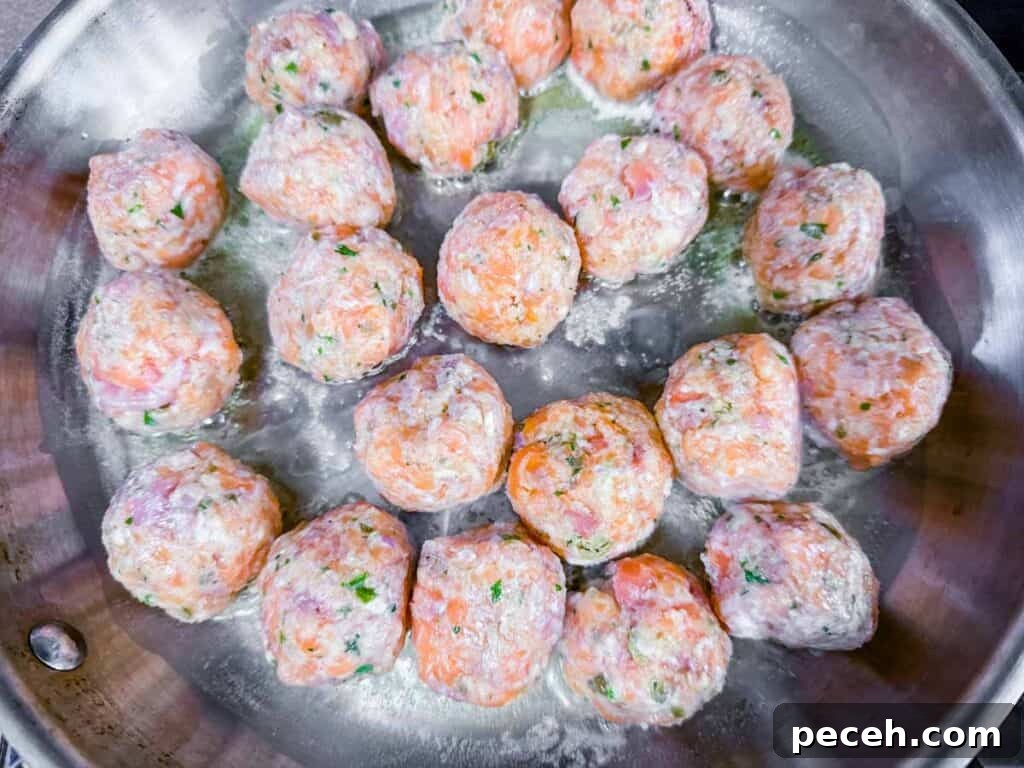 Crispy Pan-Fried Salmon Balls with Tangy Dill Sauce 13 Overhead shot of raw salmon balls cooking in a pan.