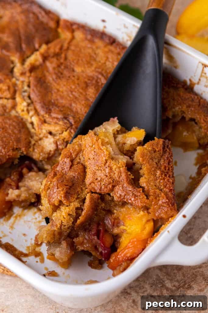 Classic Old-Fashioned Peach Cobbler Recipe You’ll Love 12 overhead shot of the old fashioned peach cobbler recipe being scooped by a spatula