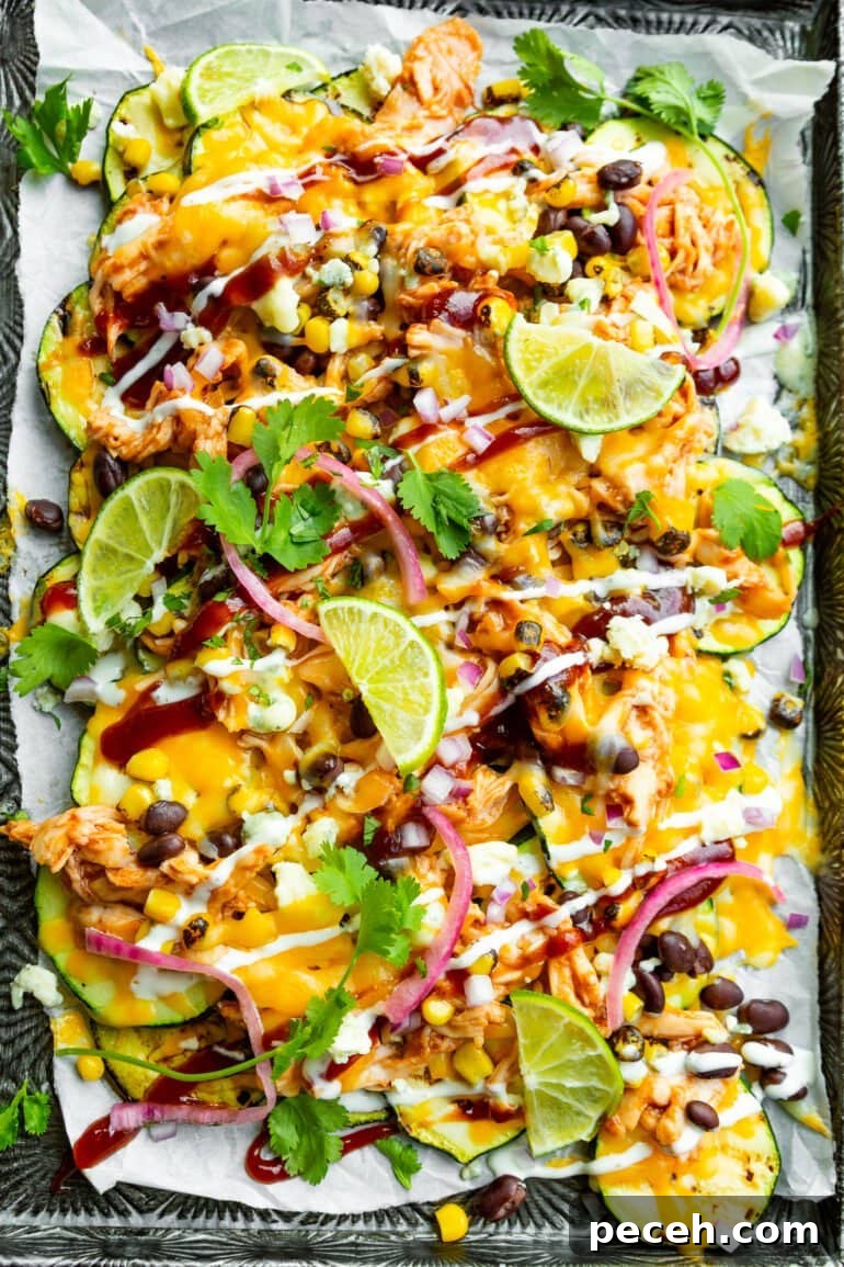 Weekly Meal Plan: Sept 18–24 with Simple Dinners and Prep Tips 6 a photo of a sheet pan full of zucchini nachos topped with melted cheese, black beans, picked red onions, fresh chopped cilantro, grilled corn, lime wedges and a drizzle of white dressing.