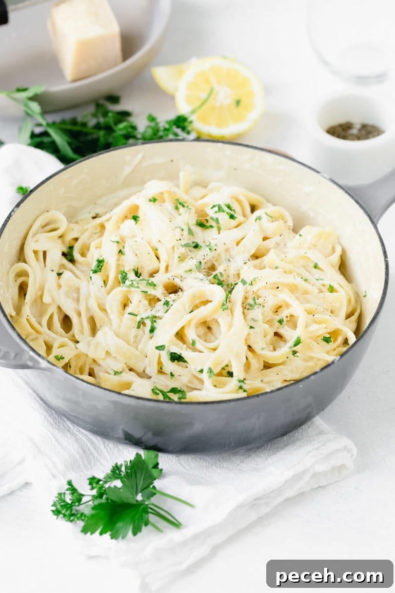 Weekly Meal Plan: Sept 18–24 with Simple Dinners and Prep Tips 9 A bowl of fettaccine alfredo. It is sprinkled with parsley and there is fresh parsley and lemon wedges next to the bowl of fettaccine alfredo.