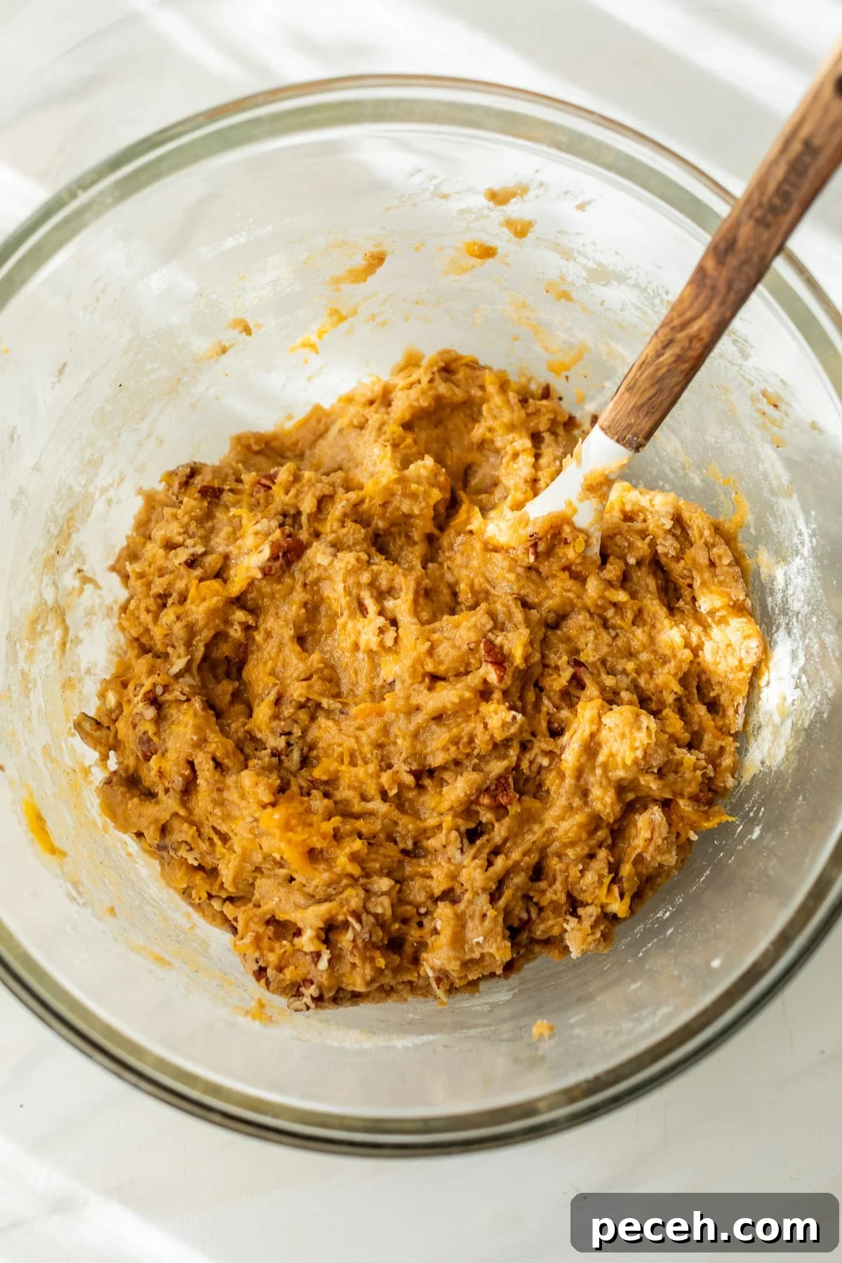 Moist Butternut Squash Loaf Recipe for Fall Baking 6 using a wooden spoon to stir the batter for butternut squash bread in a large glass bowl.