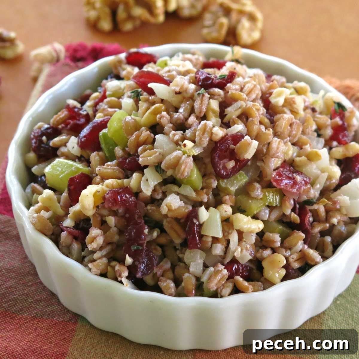 Hearty Farro Pilaf with Roasted Vegetables and Herbs 2 Farro stuffing with cranberries, walnuts, onion, and celery in a serving bowl.