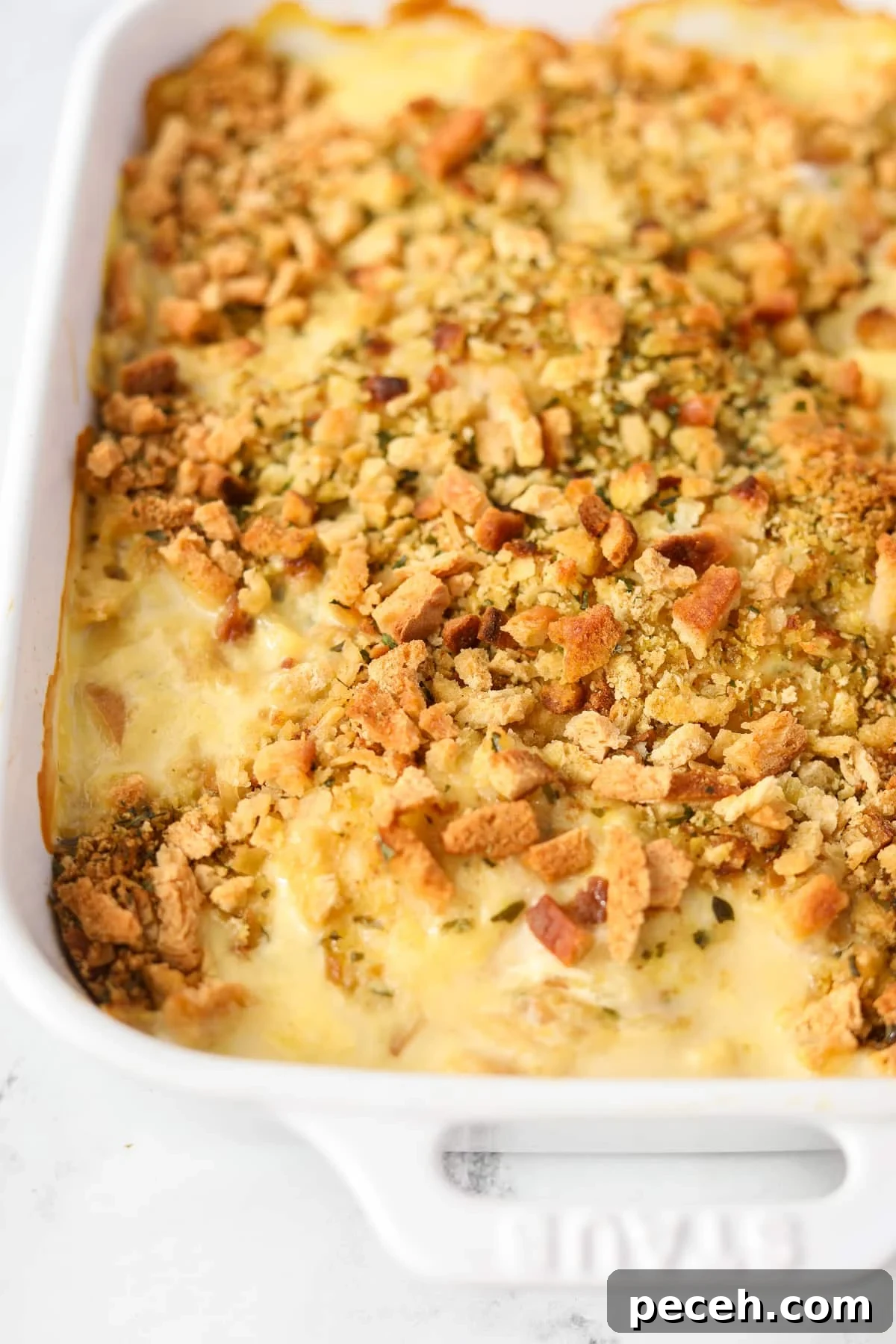 Creamy Swiss-Style Chicken Casserole with Mushrooms and Cheese 14 A close up of a baking dish filled with a stuffing-topped casserole.