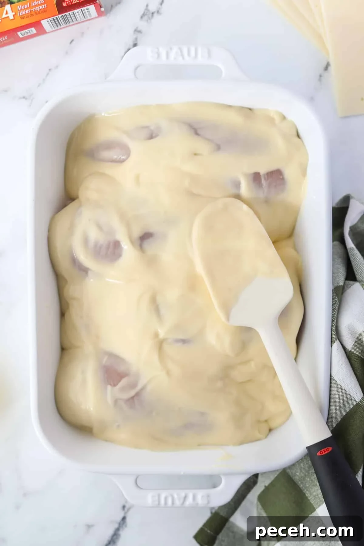 Creamy Swiss-Style Chicken Casserole with Mushrooms and Cheese 7 Spreading a soup mixture on top of chicken breasts.