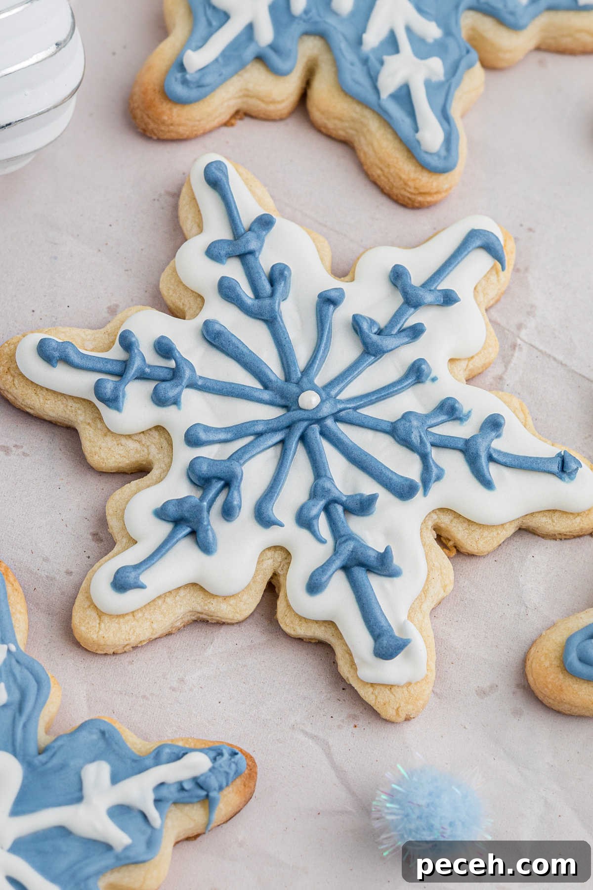 Snowflake Sugar Cookies: Festive Icing & Decorating Guide 9 Close up of a snowflake cookie with white and blue icing.