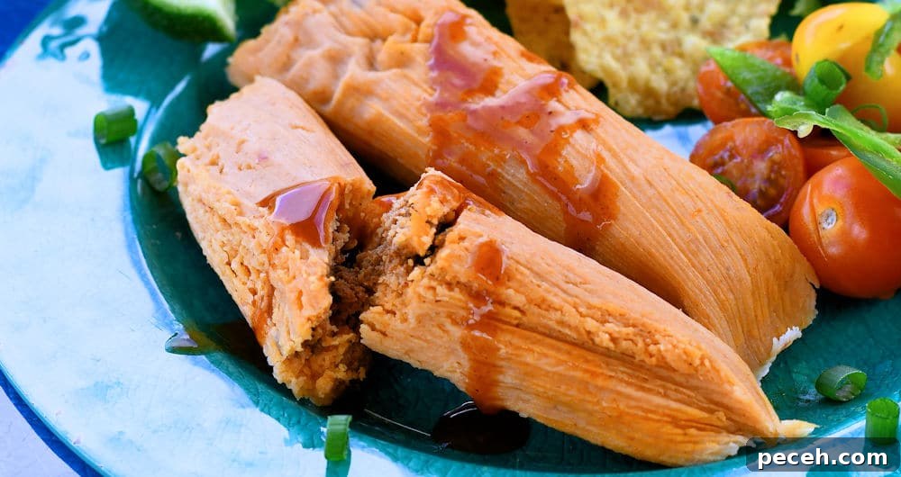 Chorizo tamales on a plate with a tomato salad