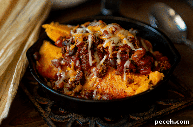 Beef short rib tamales in a black bowl sved with beans and melted cheese.
