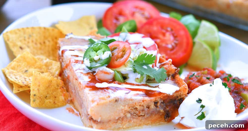 Pork tamale casserole, cut into a square and served with tomato, corn chips and salsa