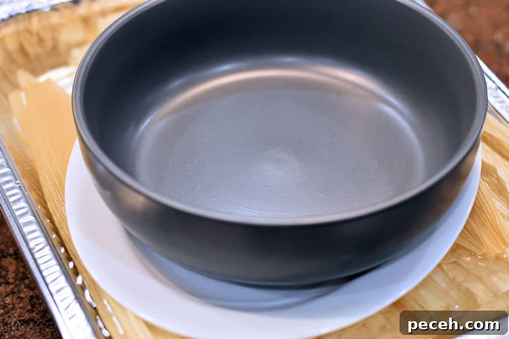 corn husks in water, topped with a heavy bowl to weight them down.