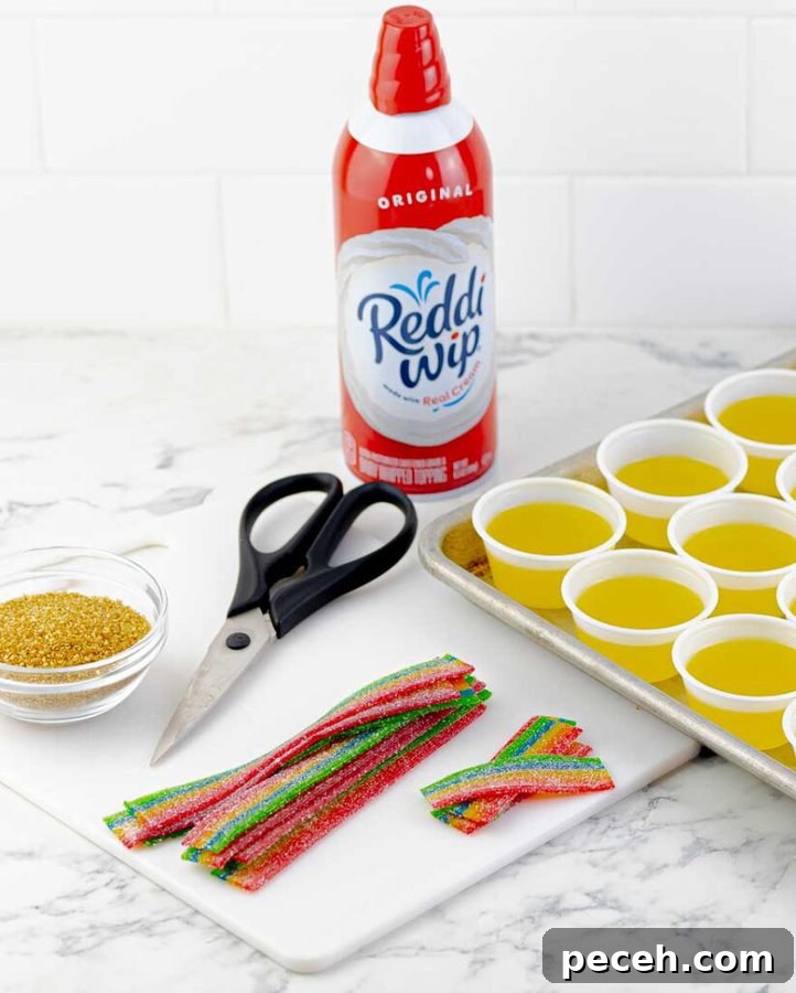 Pot of Gold Jello Shots for St. Patrick's Day 5 whipped cream, gold sprinkles, and rainbow candies for shot topping