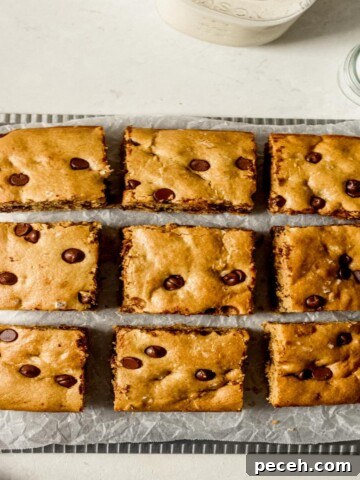 Chocolate chip cookie bar squares on wax paper.