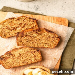 Slices of banana bread on a cutting board lined with parchment paper.