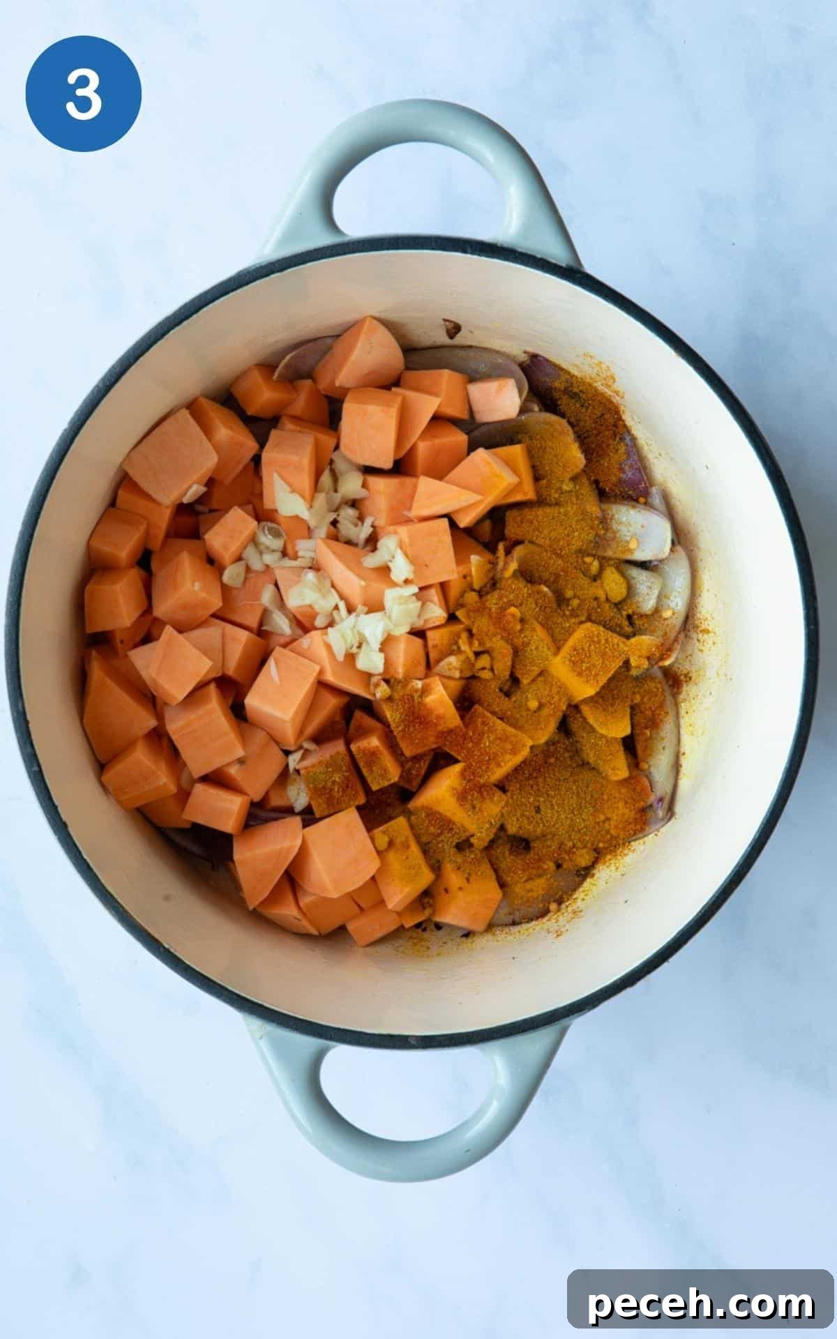 Creamy Sweet Potato Satay Curry with Coconut & Lime 6 Pot displayed on white marble background with uncooked chopped sweet potato, onions, garlic inside.