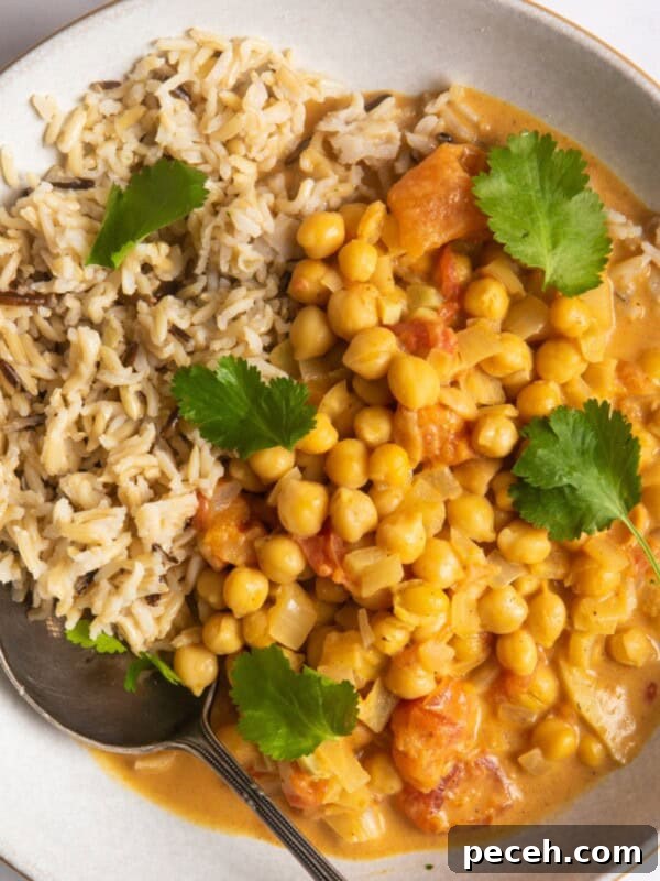 Creamy Sweet Potato Satay Curry with Coconut & Lime 10 Chickpea curry with rice in a shallow white bowl.