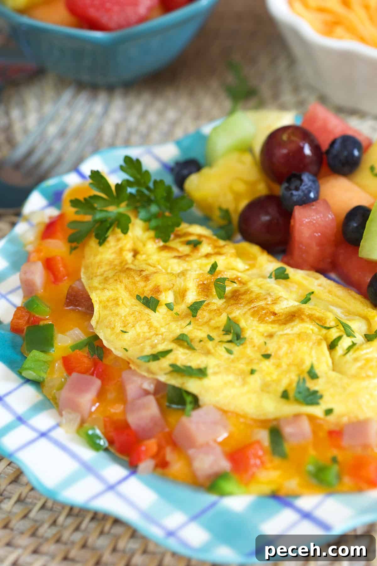 Leftover Ham Recipes: Tasty Ideas for Simple Meals 6 An omelette is on a plaid blue and white plate.