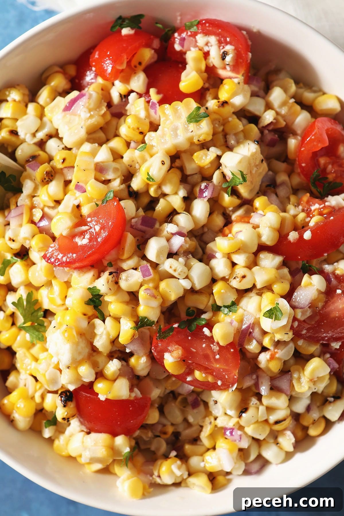 Smoky Charred Corn Salsa with Cilantro and Lime 2 Close up of Grilled Corn Salsa in a bowl with tomatoes, limes and parsley