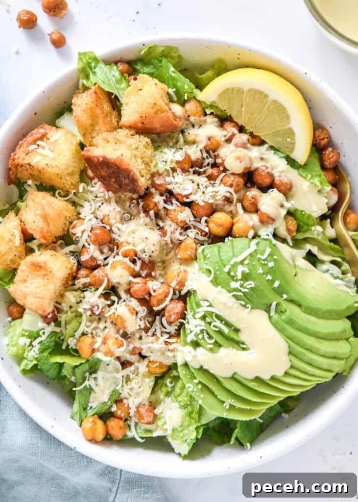 Crispy Roasted Chickpea Caesar Salad 2 roasted chickpea caesar salad with avocado and croutons in a white bowl.